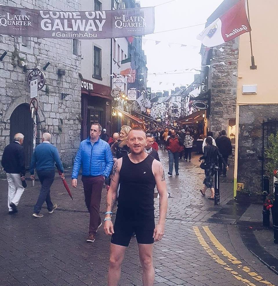 Gary wearing running clothing, standing in a busy street.